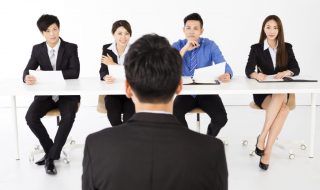 Business people interviewing young businessman in office