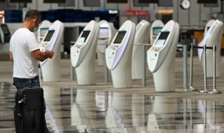a-traveller-stands-near-automated-check-in-kiosks-at-changi-international-airport-singapore