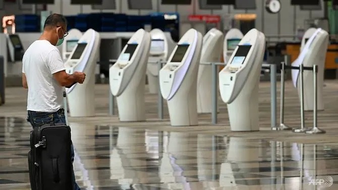 a-traveller-stands-near-automated-check-in-kiosks-at-changi-international-airport-singapore