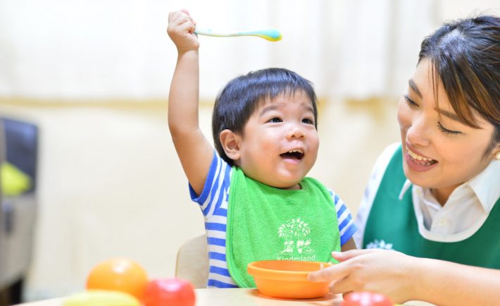 infant with a teacher at mealtime