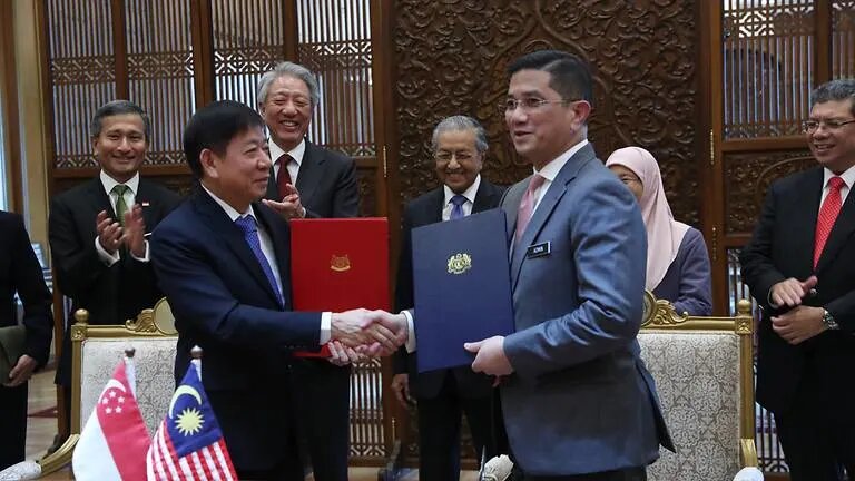 Singapore Transport Minister Khaw Boon Wan (left) and Malaysian Economic Affairs Minister Azmin Ali exchange documents in Putrajaya on Sep 5, 2018