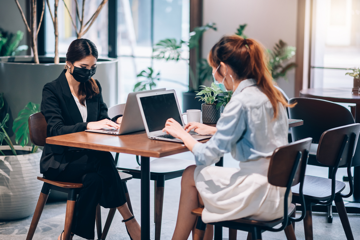 women in masks working at a desk