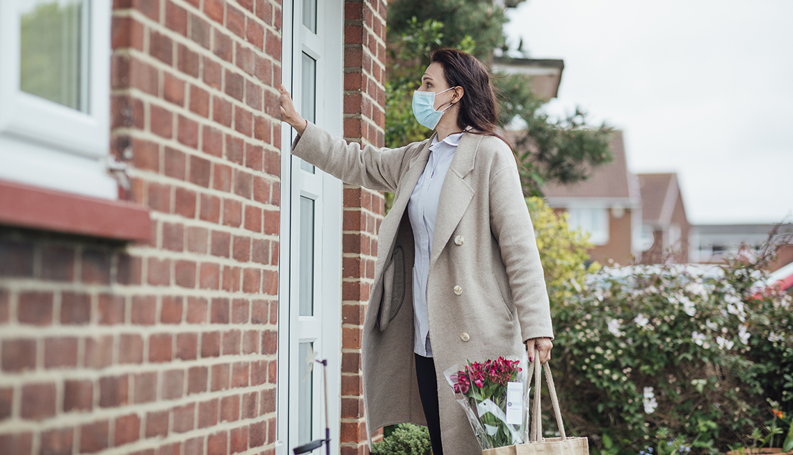 a lady with a face mask knocking on the door