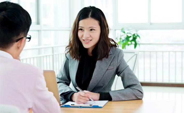 a woman listening to a man and taking notes