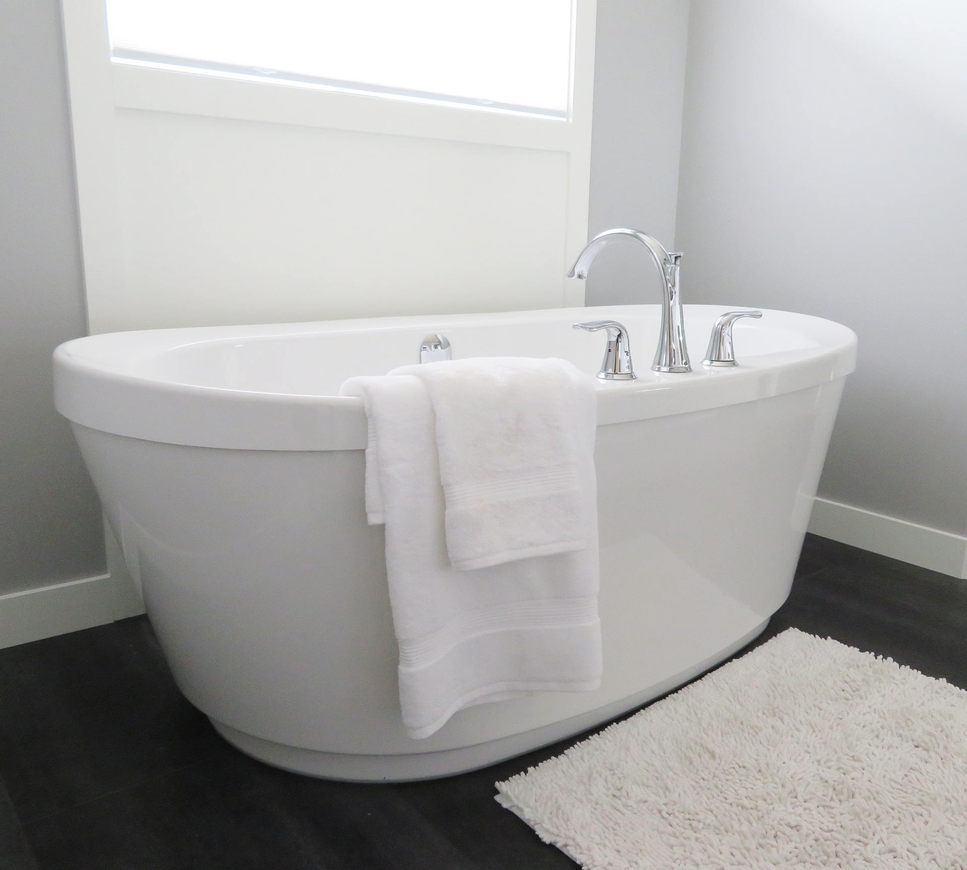 a white bathtub with a towel