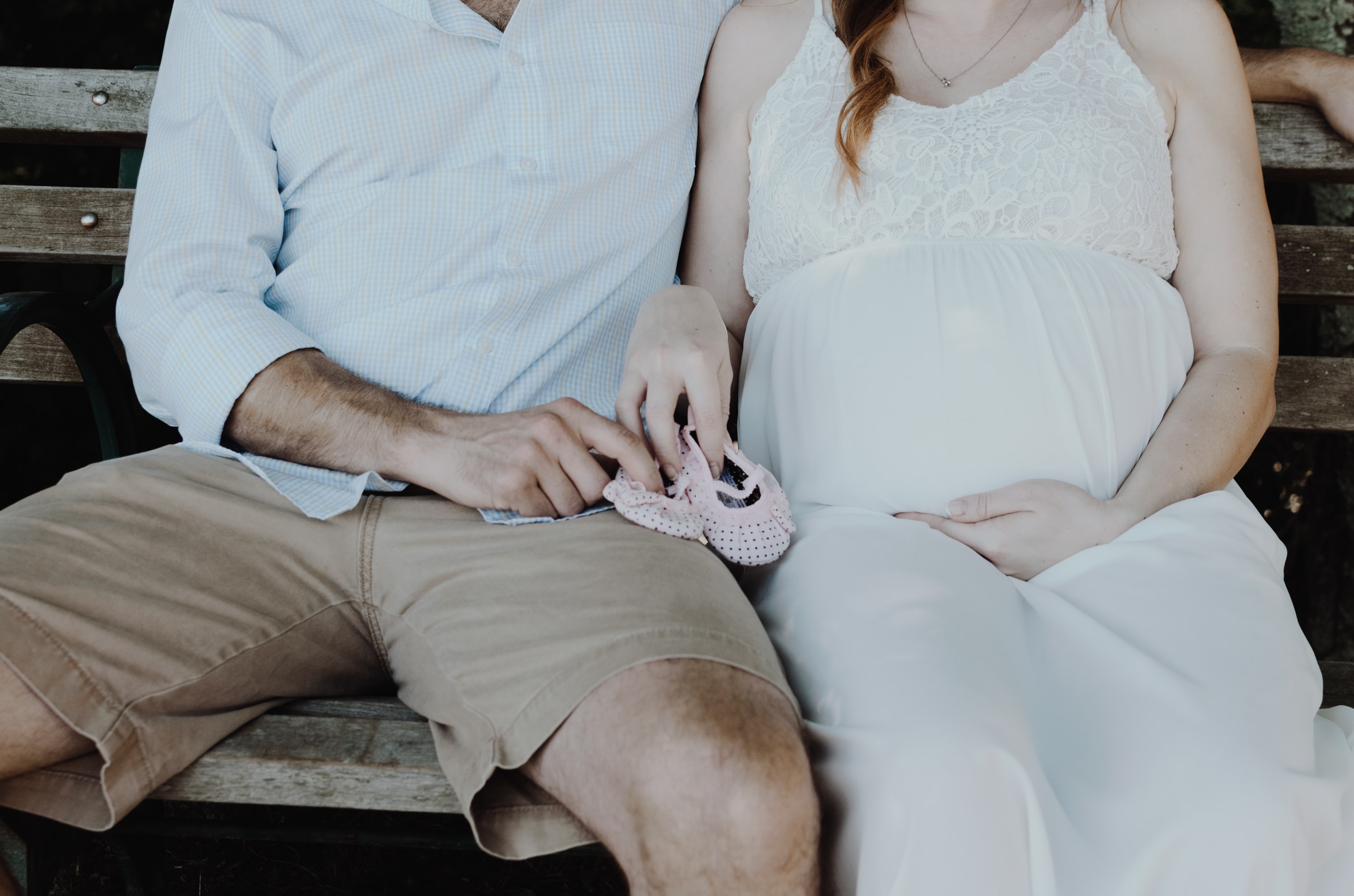 an expectant couple sitting on a bench