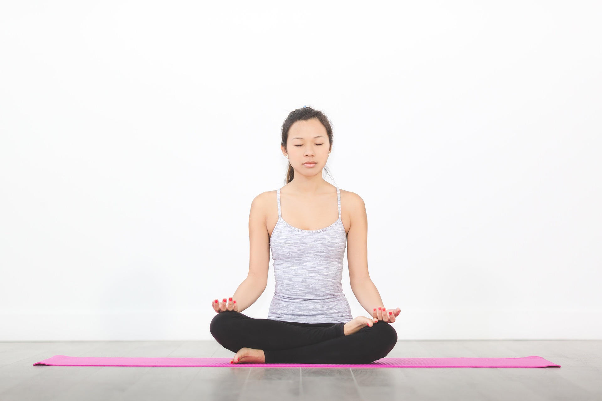 an asian woman meditating on a yoga mat