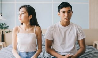 young-couple-sitting-on-their-bed