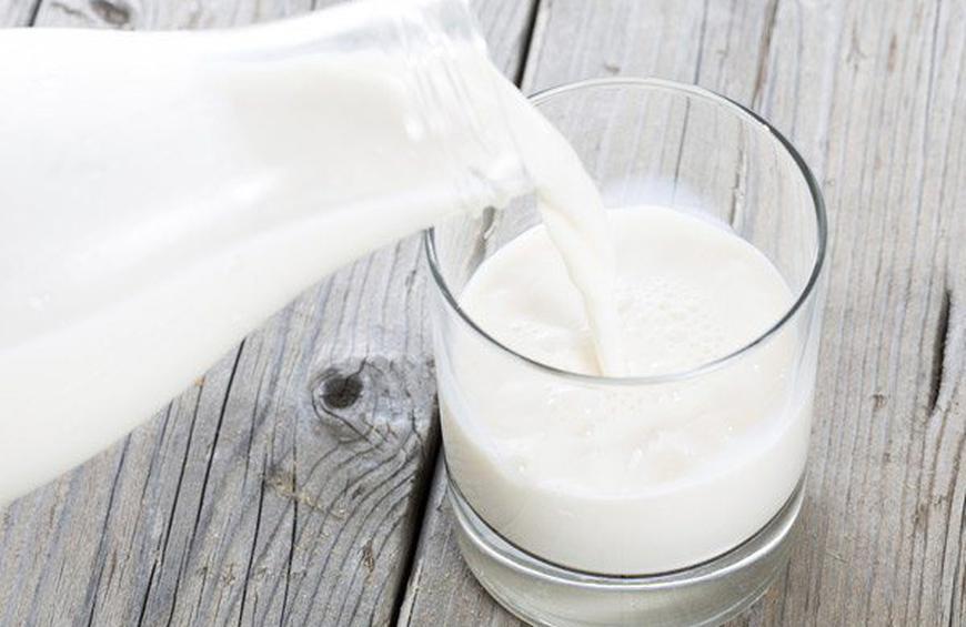 pouring milk into a glass cup