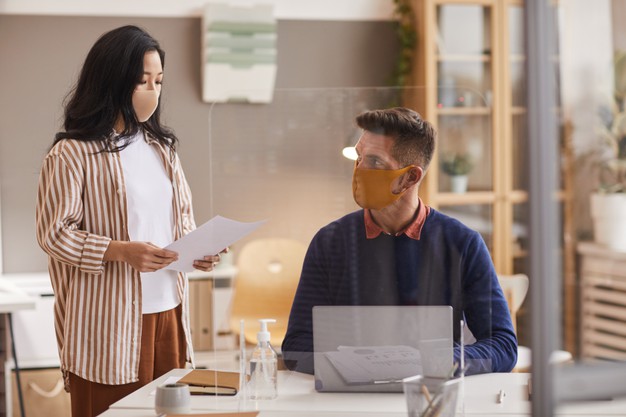 two-business-people-wearing-face-masks-while-discussing