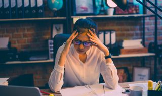 a stressed woman sitting in front of her desk