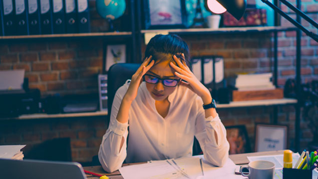 a stressed woman sitting in front of her desk