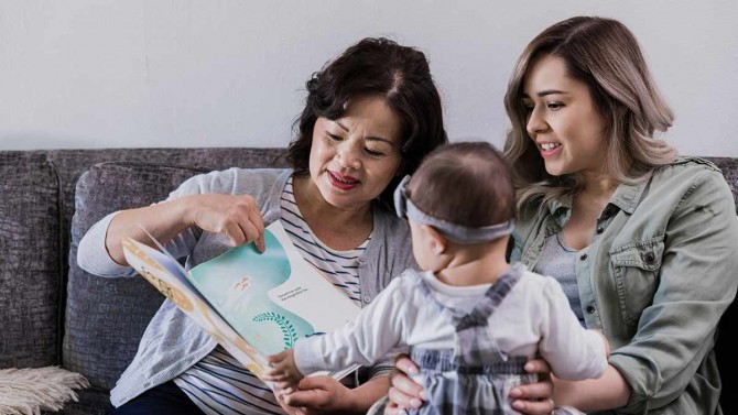 a grandmother reading a storybook to her grandchild