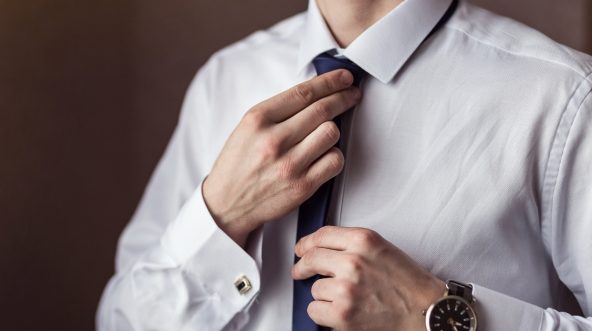 a man adjusting his tie