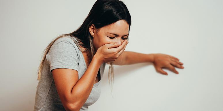 a woman covering her mouth almost vomiting