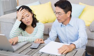 an asian couple stressed while doing calculations