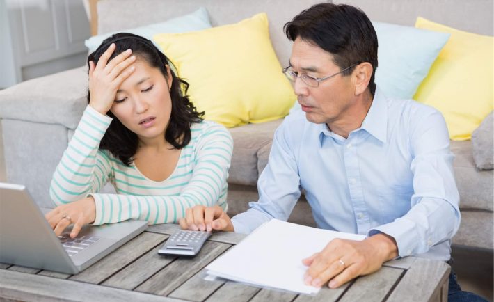 an asian couple stressed while doing calculations