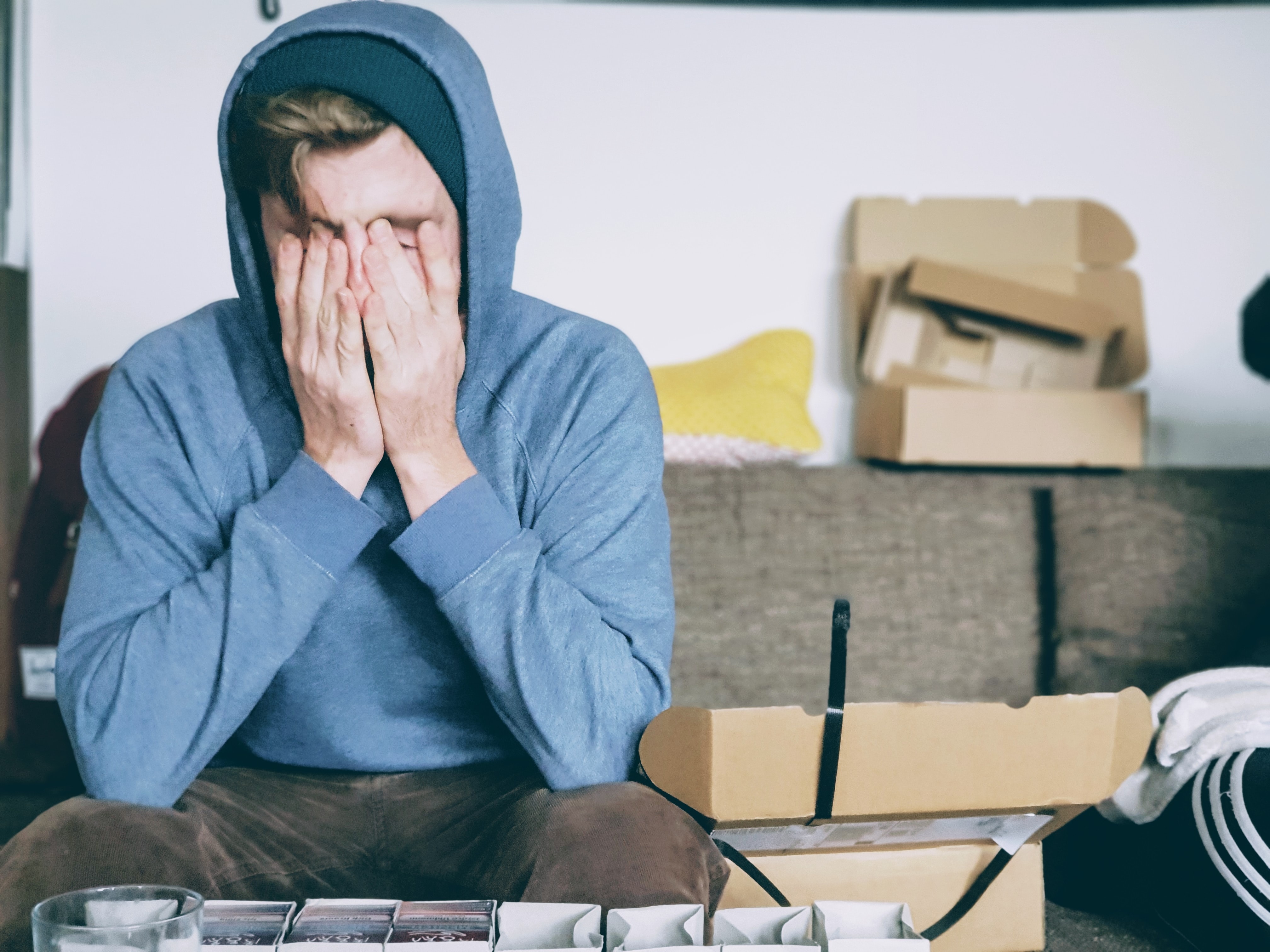 a man covering his face with both hands