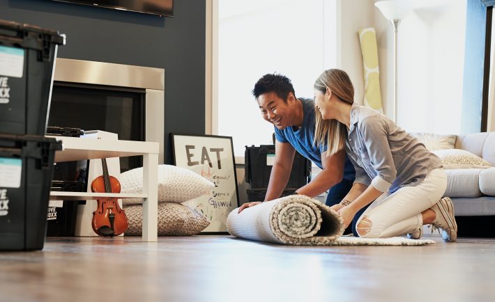 an asian couple rolling out a carpet