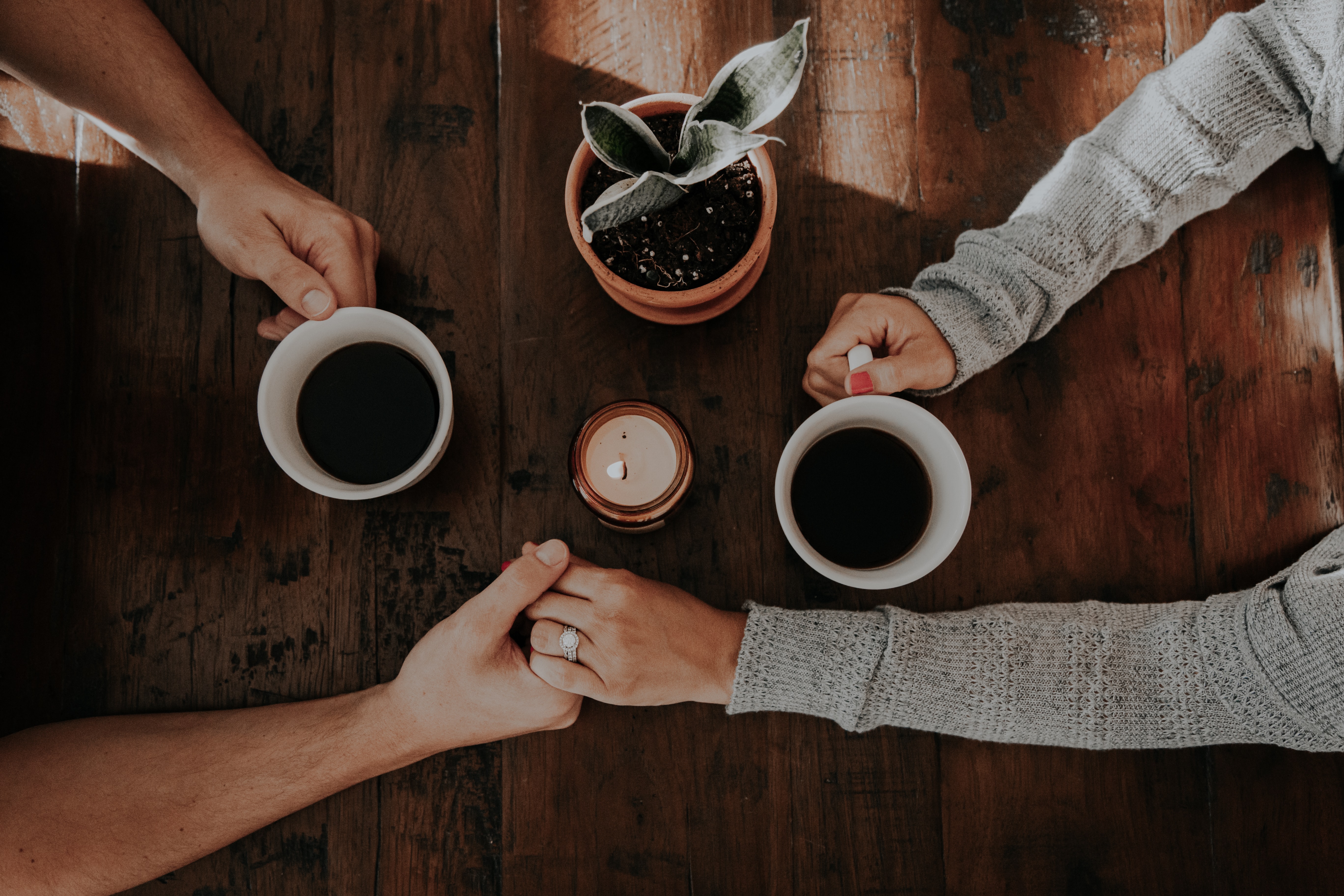 a couple holding hands at the coffee table