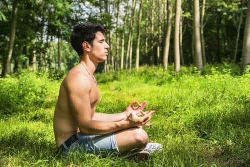 a shirtless man meditating