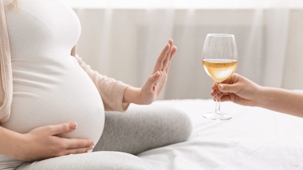 a pregnant woman saying no to alcohol