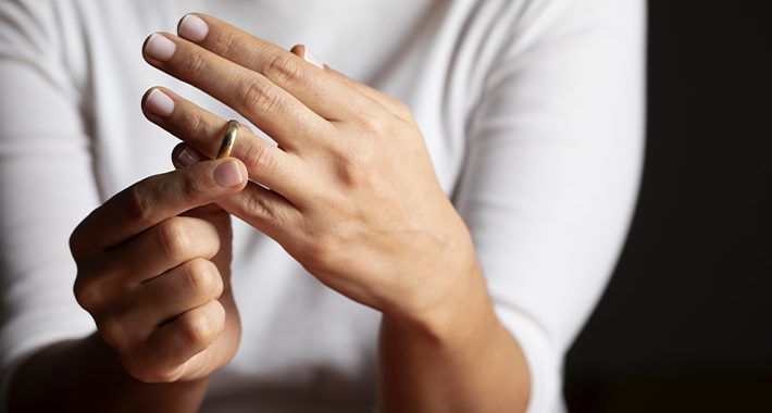 a woman removing her wedding ring