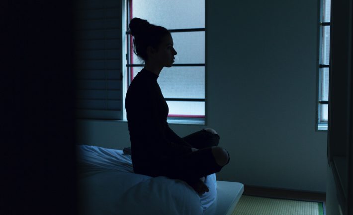 a woman sitting on her bed