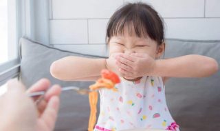 a fussy Asian child at mealtime