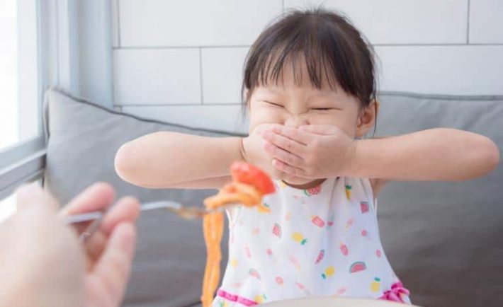 a fussy Asian child at mealtime