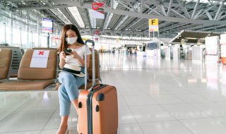 a masked lady with a luggage