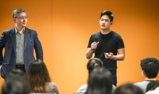 a young Asian man speaking publicly