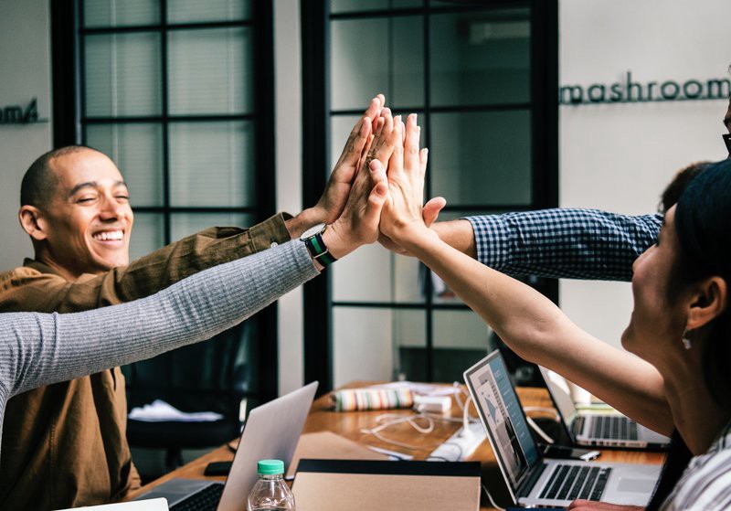 happy colleagues doing a hi-five