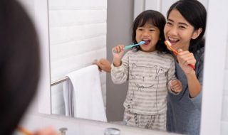 mother and child brushing teeth