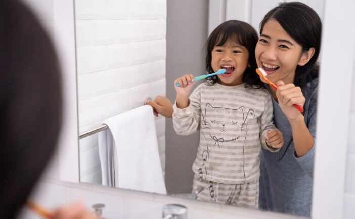 mother and child brushing teeth