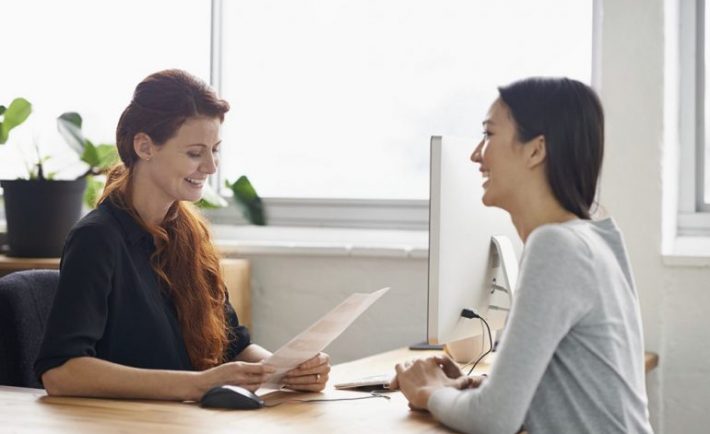 two ladies conversing and smiling