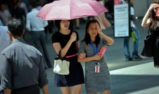 two office workers under an umbrella