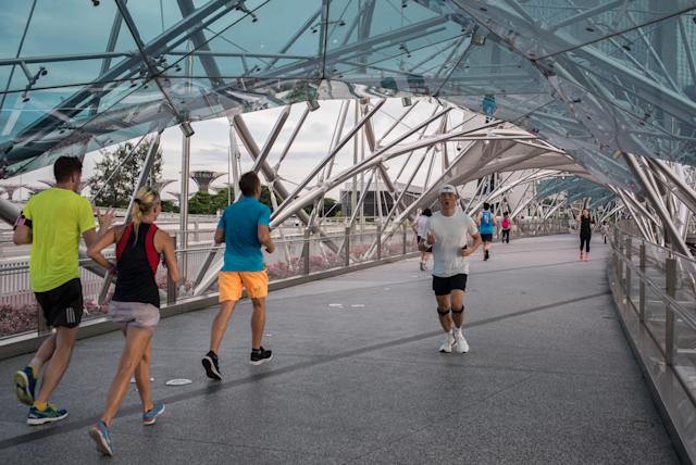 people running past the helix bridge