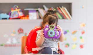 a little girl looking through a toy camera