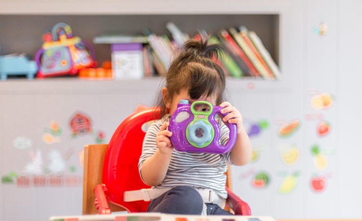 a little girl looking through a toy camera