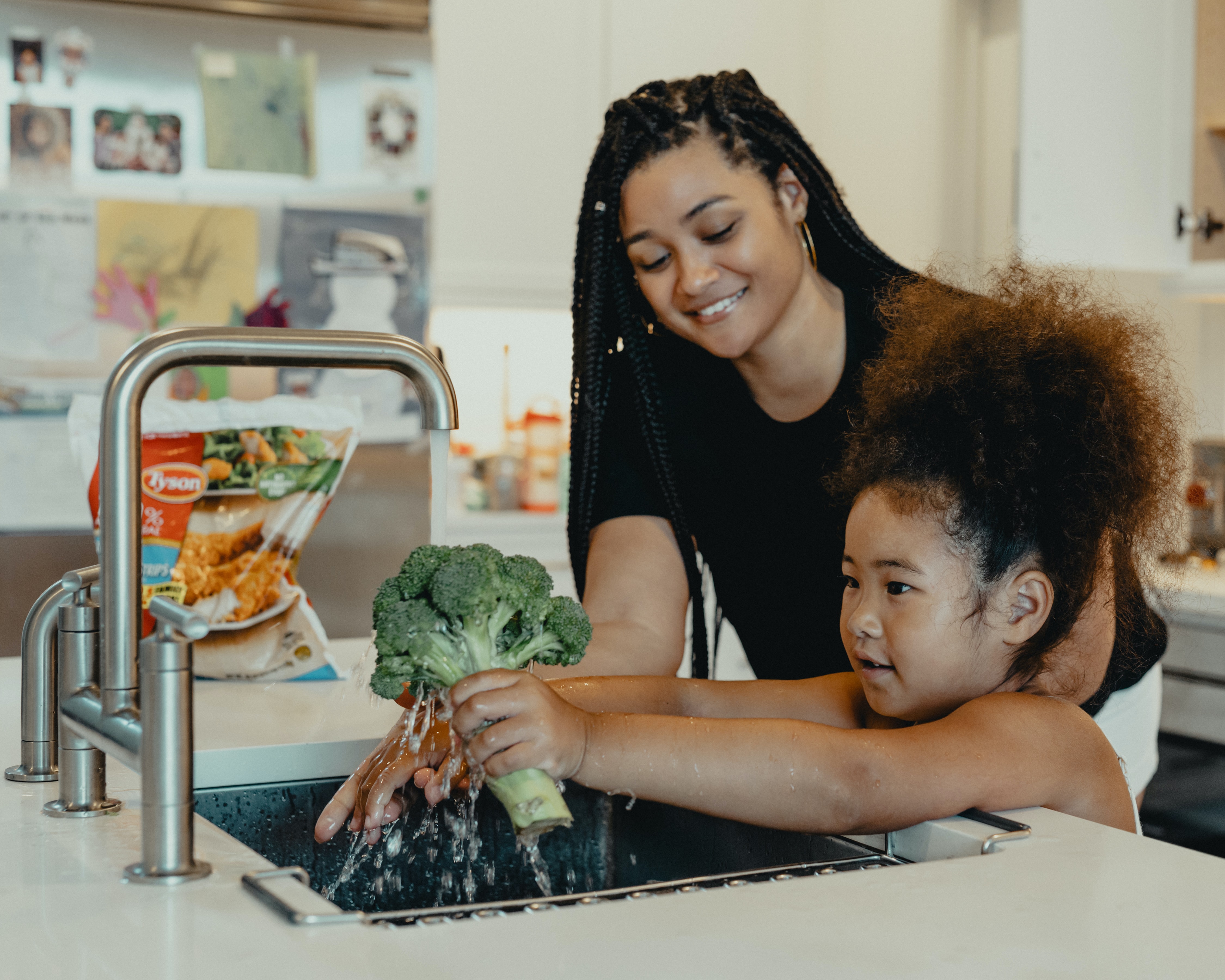 a child washing broccoli