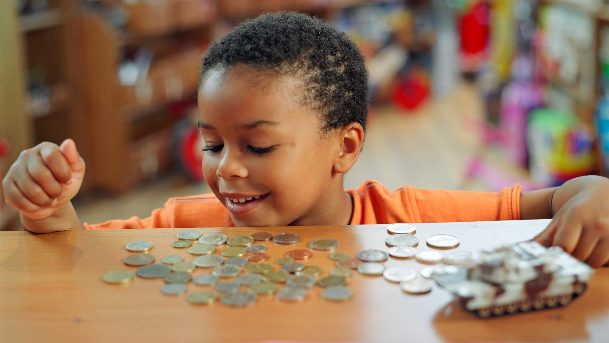 a child smiling at the coins he saved