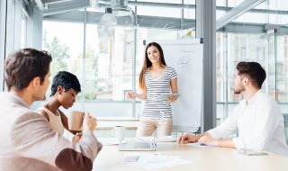 a lady presenting confidently in front of her colleagues