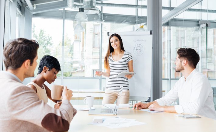 a lady presenting confidently in front of her colleagues