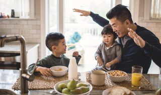 father and children communicating over breakfast