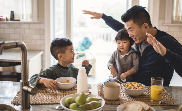 father and children communicating over breakfast