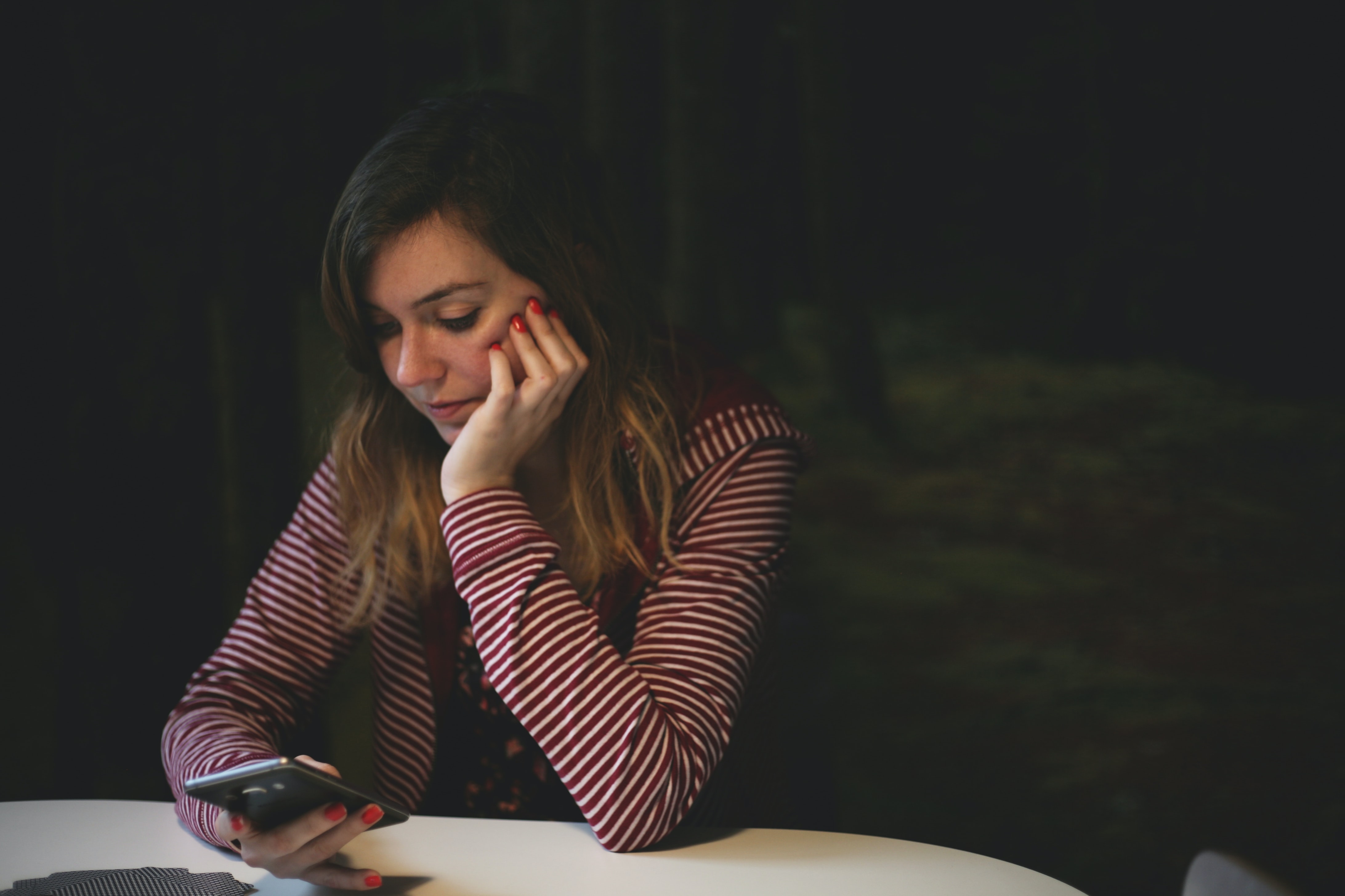 a woman in deep thought while looking at her phone