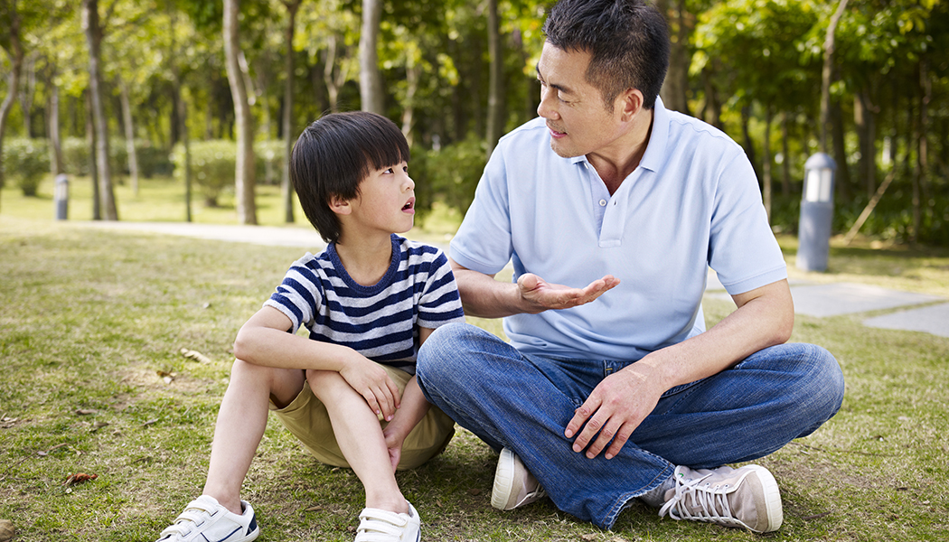 a father talking to his son in a park