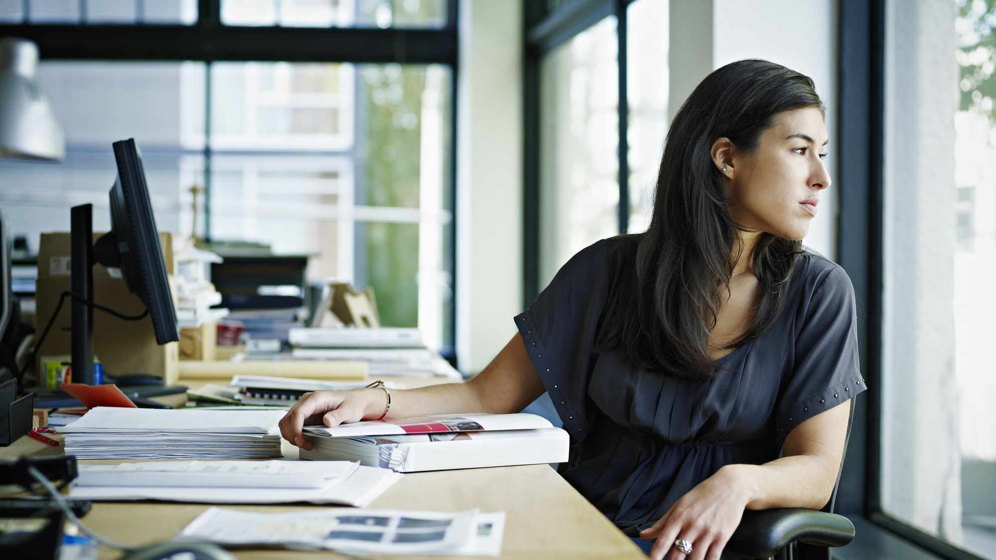 a woman looking out of the window from her desk