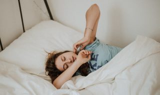 a woman struggling to get out of bed